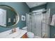 Stylish bathroom with teal walls, a gold-framed mirror, a glass-enclosed shower, and modern fixtures at 3025 Buckeley Cir, Charleston, SC 29414