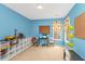 Bright blue bedroom with a gaming setup, shelving unit, and a window providing natural lighting at 3025 Buckeley Cir, Charleston, SC 29414