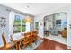 Bright dining area featuring a wood table set, a large window with pond views, and hardwood floors, adjacent to the living room at 3025 Buckeley Cir, Charleston, SC 29414