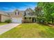 Inviting two-story home with a well-maintained lawn, attached garage, and cozy front porch at 3025 Buckeley Cir, Charleston, SC 29414