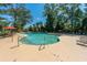 Large community pool with lounge chairs, tables, and umbrellas, surrounded by mature trees under a bright sky at 3025 Buckeley Cir, Charleston, SC 29414