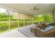 Covered porch with wicker furniture, and a picturesque view of the lake and the green backyard at 3025 Buckeley Cir, Charleston, SC 29414