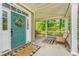 Inviting front porch with a teal door, hanging swing, and a cozy seating area at 3025 Buckeley Cir, Charleston, SC 29414