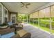 Screened porch with wicker furniture, ceiling fan, and a view of the fenced backyard and the lake at 3025 Buckeley Cir, Charleston, SC 29414