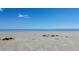 Tranquil beach scene with soft sand meeting a serene, expansive ocean under clear skies at 3030 Brownell, Sullivans Island, SC 29482