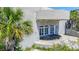 Unique concrete building entrance featuring white-framed glass doors and lush landscaping at 3030 Brownell, Sullivans Island, SC 29482