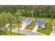Aerial view of charming, blue two-story home with a well-manicured lawn and long driveway at 307 Theus Pl, Huger, SC 29450