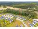 Wide aerial shot showcases the blue home, its location in a community with lush surrounding forest at 307 Theus Pl, Huger, SC 29450