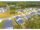 Aerial view of lovely blue home with green lawn surrounded by similar homes in an established neighborhood at 307 Theus Pl, Huger, SC 29450