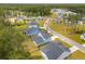 Aerial view of blue home with neutral trim, dark roof, and lawn in a neighborhood with mature trees at 307 Theus Pl, Huger, SC 29450