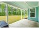Outdoor back patio with blue ceiling, concrete floor, and a view of a large, green fenced-in backyard at 307 Theus Pl, Huger, SC 29450