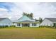 View of the home's exterior featuring a spacious backyard, manicured lawn and privacy fence at 307 Theus Pl, Huger, SC 29450