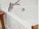 A modern bathtub with a sleek silver faucet, wooden stool, and textured towel accents at 307 Theus Pl, Huger, SC 29450