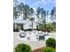 Community amenities, showcasing an outdoor fire pit with seating, a grassy area, and clubhouse at 307 Theus Pl, Huger, SC 29450
