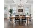 Dining room featuring a long wooden table with black chairs, a plant, and large windows at 307 Theus Pl, Huger, SC 29450
