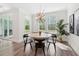 A round dining table with four chairs sits beneath a modern light fixture and near sliding glass doors at 307 Theus Pl, Huger, SC 29450