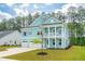 Two-story home with light blue exterior, three-car garage and well-manicured lawn at 307 Theus Pl, Huger, SC 29450
