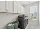 Laundry room with white cabinets, gray machines, and light blue rug at 307 Theus Pl, Huger, SC 29450