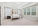 A main bedroom featuring a four-poster bed, large windows, and tray ceilings at 307 Theus Pl, Huger, SC 29450
