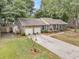 Aerial view of a brick home featuring a two-car garage, mature trees, and front yard at 31 Monte Sano Dr, Hanahan, SC 29410
