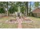 Backyard featuring raised garden beds with brick borders, surrounded by mature trees at 31 Monte Sano Dr, Hanahan, SC 29410