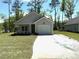 Charming single-story home featuring a well-manicured lawn and a convenient attached garage at 3214 Pinewood Dr, Ladson, SC 29456
