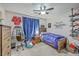 Comfortable bedroom with bed, blue curtains, a ceiling fan, desk, and baseball themed decor at 3230 Landing Pkwy, North Charleston, SC 29420