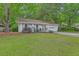 Well-maintained one-story home with a lush green lawn and mature trees for added privacy at 3230 Landing Pkwy, North Charleston, SC 29420