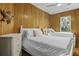 Bedroom featuring wood paneled walls, twin beds with plush linens, dresser and natural light from the window at 3320 Myrtle St, Edisto Island, SC 29438