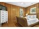 Bedroom boasts wood paneled walls, wood floors, and a wicker-style bed frame at 3320 Myrtle St, Edisto Island, SC 29438