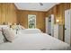 Bedroom featuring wood paneled walls, twin beds with plush linens, dresser and natural light from the window at 3320 Myrtle St, Edisto Island, SC 29438