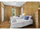 Cozy bedroom features wood paneled walls, twin beds with plush linens, and natural light from the window at 3320 Myrtle St, Edisto Island, SC 29438