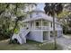 Stately home surrounded by lush trees, features covered porches and a towering palm tree at 3320 Myrtle St, Edisto Island, SC 29438