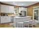 Modern kitchen equipped with white cabinets, stainless steel appliances, and a functional island with seating at 3320 Myrtle St, Edisto Island, SC 29438