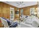 Relaxing living room with white sofas, wood paneling, and natural light streaming through the windows at 3320 Myrtle St, Edisto Island, SC 29438