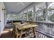 Relaxing screened porch with dining table and ample seating overlooking a lush green landscape at 3320 Myrtle St, Edisto Island, SC 29438