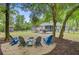 Back yard with fire pit and adirondack chairs. Features patio and mature shade trees at 3360 Fickling Hill Rd, Johns Island, SC 29455