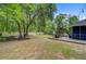 Back yard with fire pit, mature shade trees, a back deck with patio table and lush lawn at 3360 Fickling Hill Rd, Johns Island, SC 29455