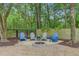 Gravel fire pit area with adirondack chairs surrounded by lush landscaping at 3360 Fickling Hill Rd, Johns Island, SC 29455
