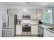 Bright kitchen with stainless steel appliances, gray cabinets, and granite countertops at 3360 Fickling Hill Rd, Johns Island, SC 29455