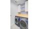 Laundry room featuring front loading washer and dryer, wood counter, and blue patterned wallpaper at 3360 Fickling Hill Rd, Johns Island, SC 29455