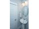 Powder room with pedestal sink, decorative mirror, modern lighting, and white painted trim at 3941 Bessemer Rd, Mount Pleasant, SC 29466