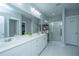 Bright bathroom featuring double sinks, white cabinets, and a walk-in shower with glass doors at 3941 Bessemer Rd, Mount Pleasant, SC 29466