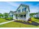 Charming two-story home with a covered front porch, manicured landscaping, and light teal siding at 3941 Bessemer Rd, Mount Pleasant, SC 29466