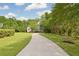 Beautiful two-story home surrounded by lush greenery with a long driveway in a wooded area at 4213 Club Course Dr, North Charleston, SC 29420