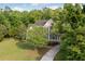 Beautiful two-story home surrounded by lush greenery with a long driveway in a wooded area at 4213 Club Course Dr, North Charleston, SC 29420