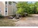 A view of the home's rear exterior, featuring a brick foundation, stairs, patio with seating, and tree at 4213 Club Course Dr, North Charleston, SC 29420