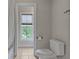 Bright bathroom features a toilet and a window with a view of the lush backyard at 4213 Club Course Dr, North Charleston, SC 29420