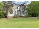 Charming two-story home with a landscaped yard and a welcoming entrance with lush green lawn at 4213 Club Course Dr, North Charleston, SC 29420