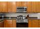 Close up of kitchen details including oven and cooktop and warm wood cabinets with stainless steel hardware at 4213 Club Course Dr, North Charleston, SC 29420